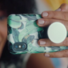 Popsocket Shown In Use To Hold Phone For Taking Photos